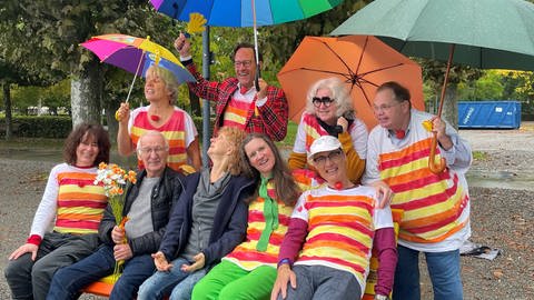 Menschen sitzen am Bodensee in Konstanz auf der Humorbank. Die Bank am Seeufer soll nicht nur zum Ausruhen, sondern auch zum miteinander Lachen einladen. Die Bank ist laut den Initiatoren die erste Humorbank Deutschlands - vielleicht sogar der Welt.