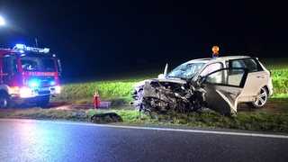 Ein zerstörtes Auto steht nach einem schweren Unfall am Straßenrand, daneben ein Feuerwehrauto. Bei dem Frontal-Crash bei Frickingen im Bodenseekreis wurden zwei Menschen lebensgefährlich verletzt 