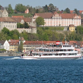 Ein Ausflugsschiff mit Touristen fährt auf dem Bodensee an Meersburg vorbei.