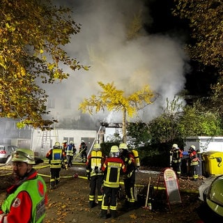 Feuerwehrleute in Überlingen vor einem brennenden Gebäude in der Hafenstraße.