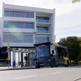 Gelb-schwarzer Kleinbus hält an Bushaltestelle vor ZF-Forum in Friedrichshafen