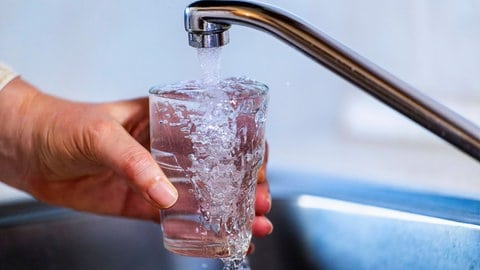 Trinkwasser läuft aus einem Wasserhahn in ein Glas. Trinkwasser aus dem Bodensee wird teurer