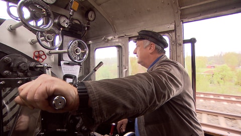 Eine historische Schmalspurbahn fährt durch die Landschaft