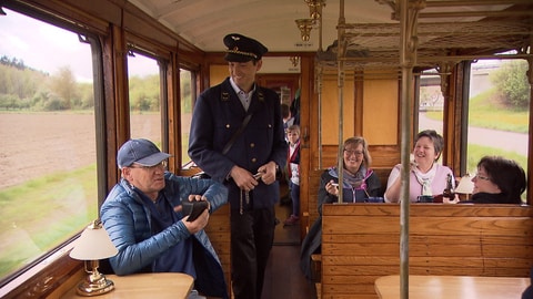 Eine historische Schmalspurbahn fährt durch die Landschaft