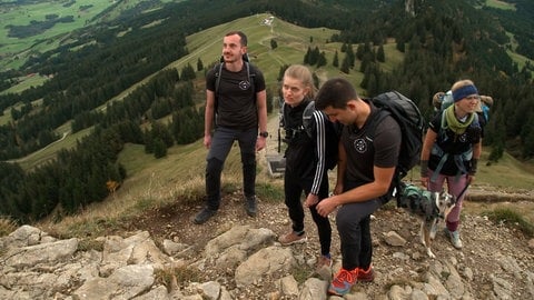 Marion Fischer und zwei Begleiter richten den Blick zum Gipfel