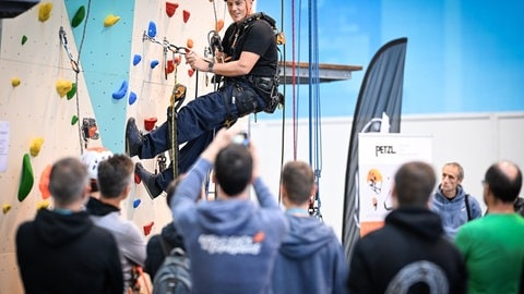 Ein Mann hängt gut gesichert in einer Kletterwand. Ums Klettern geht es bei der Messe Vertical Pro in Friedrichshafen.