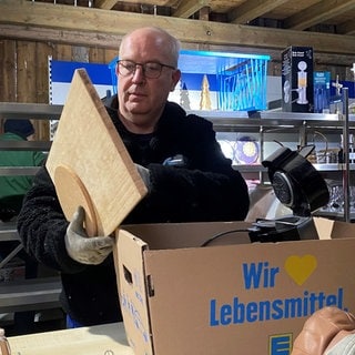 Roland Grieser prüft ein Vesperbrett beim Tauschtreff im Biberacher Ortsteil Reute. Nicht jedes Teil darf auch in die Regale.