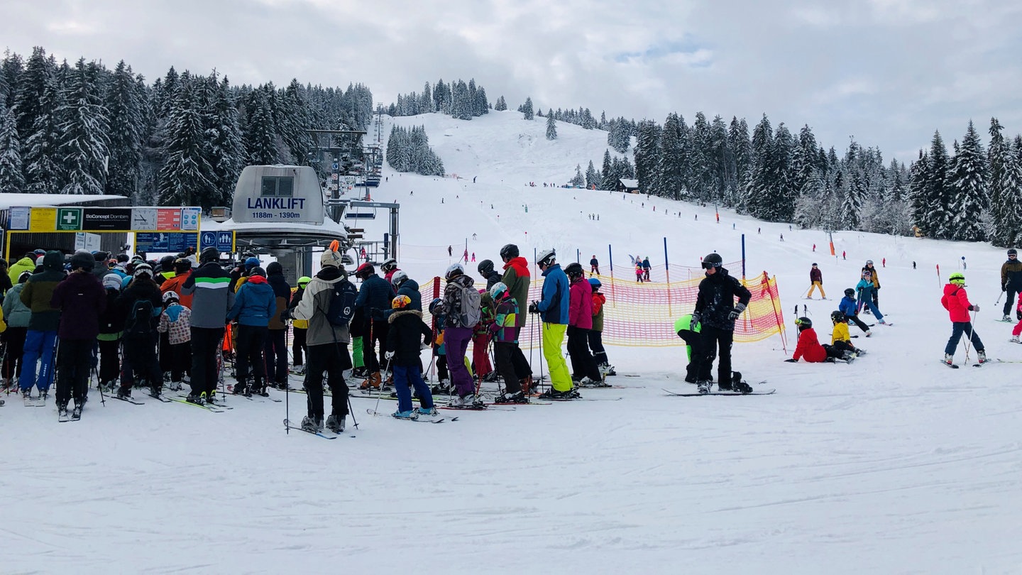 Menschen stehen in einer Schlange vor einem Skilift im Skigebiet Bödele in Vorarlberg