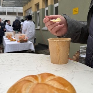 Ein Obdachloser isst Suppe in Weingarten.