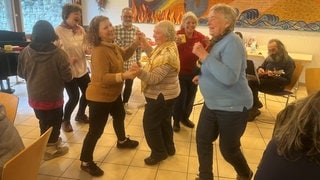 Fröhliche Stimmung beim Weihnachtsfrühstück für Wohnsitzlose und Alleinstehende von der Caritas in Konstanz.