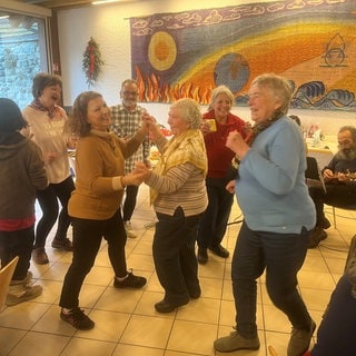 Fröhliche Stimmung beim Weihnachtsfrühstück für Wohnsitzlose und Alleinstehende von der Caritas in Konstanz.