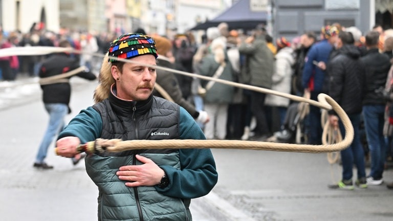 Daniel Sinner, Narr der Hänselezunft Überlingen (HZÜ), schnellt wie duztenden anderer Narren mit Karbatschen vor dem Münster die Fasnacht ein.