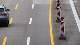 Ein PKW fährt über eine verengte Fahrbahn in einer Baustelle auf der Autobahn 