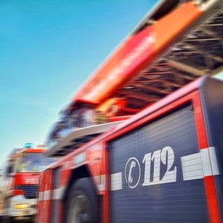 Zwei Einsatzfahrzeuge der Feuerwehr mit großer Aufschrift 112. Grafischer Effekt. Symbolbild