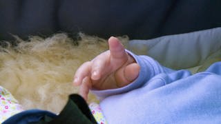 Ein Baby streckt seine Finger in die Luft
