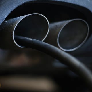 Der Messschlauch eines Geräts zur Abgasuntersuchung für Dieselmotoren steckt im Auspuffrohr eines Audi A4 TDI in einer Werkstatt 