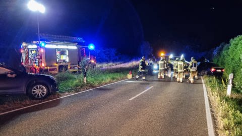 Ein schwer beschädigtes schwarzes Auto nach einem Frontalzusammenstoß