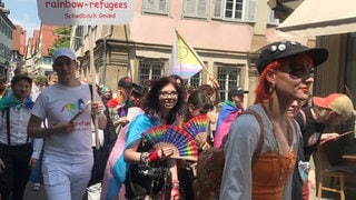 Queere und Unterstützer laufen beim Christopher Street Day bunt gekleidet durch die engen Gassen Schwäbisch Halls.