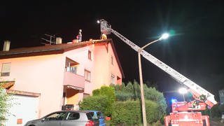 Die Feuerwehr repariert mit Drehleitern notdürftig Dächer mit Planen