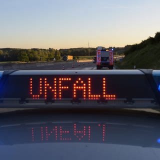 Auf einem Polizeifahrzeug warnt eine Leuchtschrift vor einer Unfallstelle