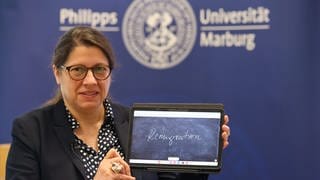 Constanze Spieß, Sprachwissenschaftlerin an der Philipps-Universität Marburg und Jury-Sprecherin, präsentiert den Begriff "Remigration" auf einem Tablet. Das «Unwort des Jahres» 2023 in Deutschland lautet «Remigration». Das gab die sprachkritische «Unwort»-Aktion am Montag in Marburg bekannt.