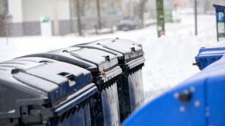 Müllcontainer sind von Schnee bedeckt.