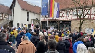 Menschen demonstrieren am Rathaus von Erlenbach