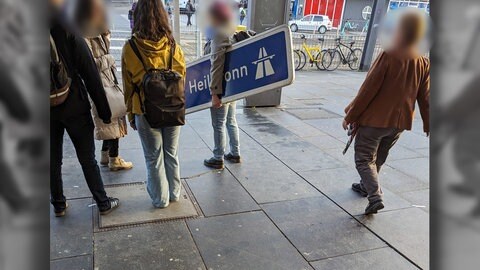 Frau mit blauem Autobahnschild