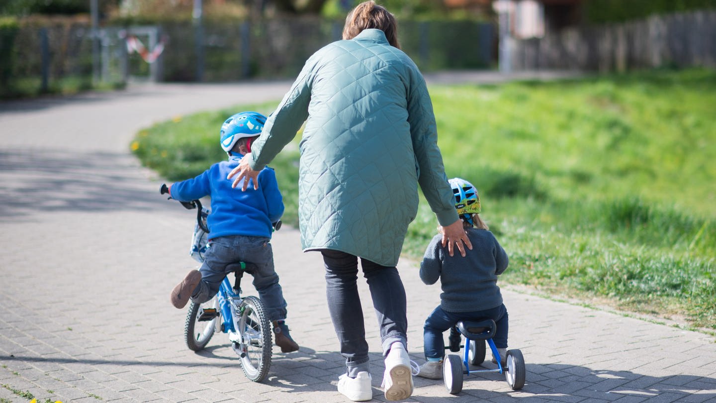 Mutter mit Kindern auf Fahrrädern (Symbolbild)