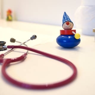 Ein Stethoskop und Kinderspielzeug liegen in einer Kinderarztpraxis