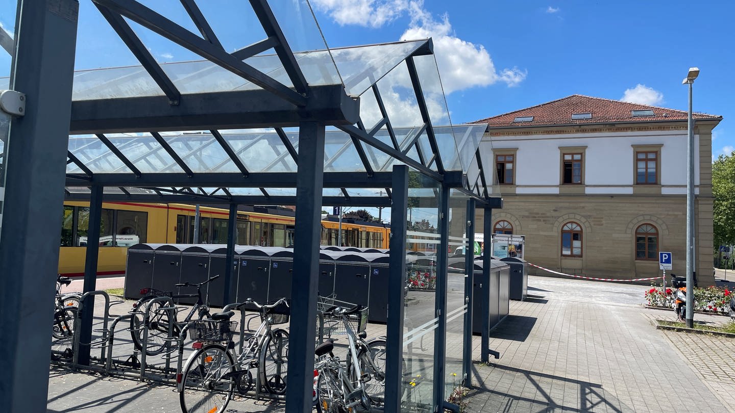 Der Bahnhof in Eppingen - Flatterband weht vor dem Hauptgebäude. Davor stehen Fahrradboxen.