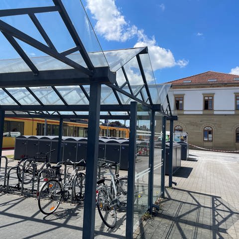 Der Bahnhof in Eppingen - Flatterband weht vor dem Hauptgebäude. Davor stehen Fahrradboxen. 