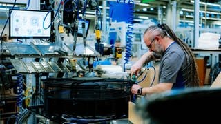 Ein Mann montiert einen Ventilator in der Produktion des Unternehmens ebm-papst.