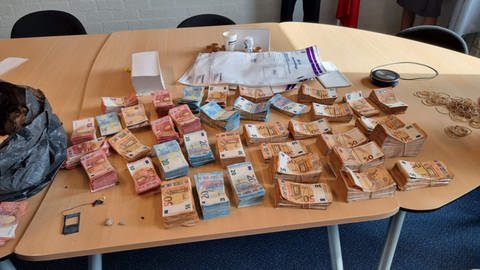 Die Beute aus Offenau: viele Geldscheine auf dem Holztisch im Polizeirevier.