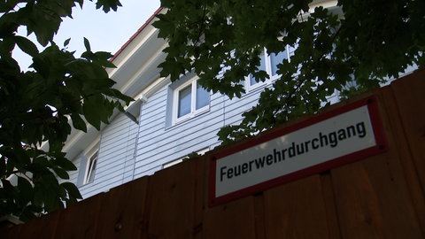 Das Obergeschoss des Mehrfamilienhauses. Davor eine Aufschrift: Feuerwehrdurchgang