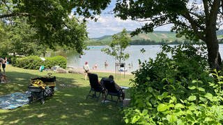 Menschen liegen auf der Wiese am Breitenauer See