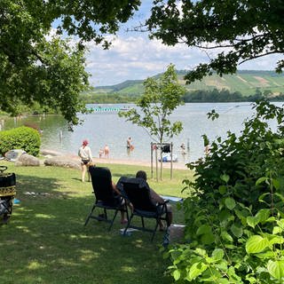 Menschen liegen auf der Wiese am Breitenauer See