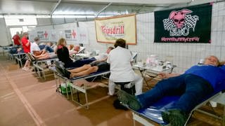Personen auf Liegen und Personal bei Blutspendeaktion in Tripsdrill (Archivfoto)