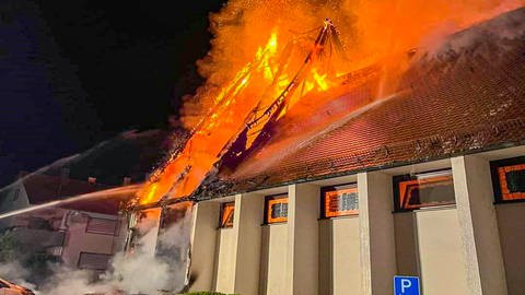 Flammen schlagen aus einem Dach: Die St. Josef Kirche in Widdern ist am Samstagabend in Brand geraten.