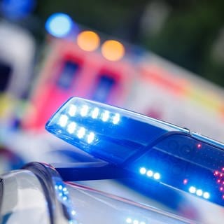 Ein Polizeiauto steht vor einem Krankenwagen.