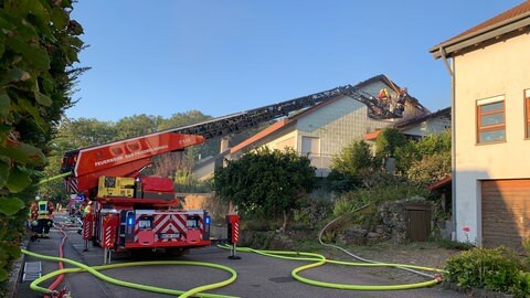 Feuerwehrauto mit Drehleiter vor Haus