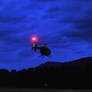 Ein Polizeihubschrauber fliegt bei Dunkelheit (Symbolbild).