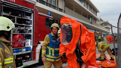 Ein Feuerwehrmann legt einen Schutzanzug an.