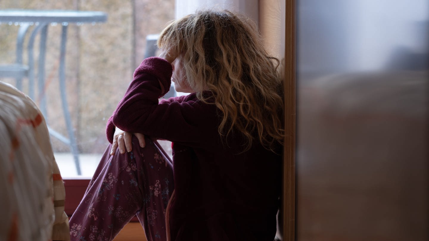 Frau sitzt am Fenster