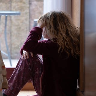 Frau sitzt am Fenster