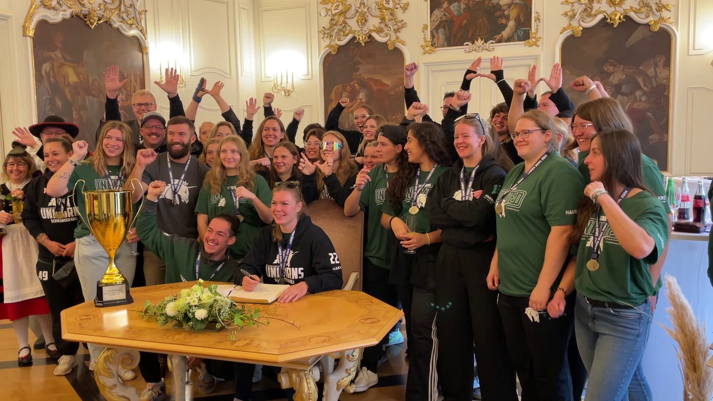 Die Damenmannschaft der Schwäbisch Hall Unicorns trägt sich ins Goldene Buch der Stadt ein.