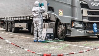 Ein Beamter der Spurensicherung arbeitet am Tatort auf einem Parkplatz in einem Industriegebiet im Kreis Schwäbisch Hall. Nach einer tödlichen Schlägerei zwischen vier Lastwagenfahrern in Baden-Württemberg wird gegen zwei der Trucker wegen gemeinschaftlichen Totschlags ermittelt.