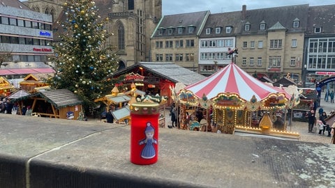 Der Veranstalter des Heilbronner Weihnachtsmarkts verteilt an die Standbesitzer Kerzen zum Gedenken an die Opfer von Magdeburg