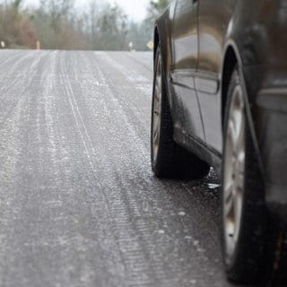 Ein Auto fährt auf einer glatten Straße (Symbolbild). Laut Polizei haben sich in der Nacht mehrere Unfälle wegen Schnee und Glatteis ereignet.