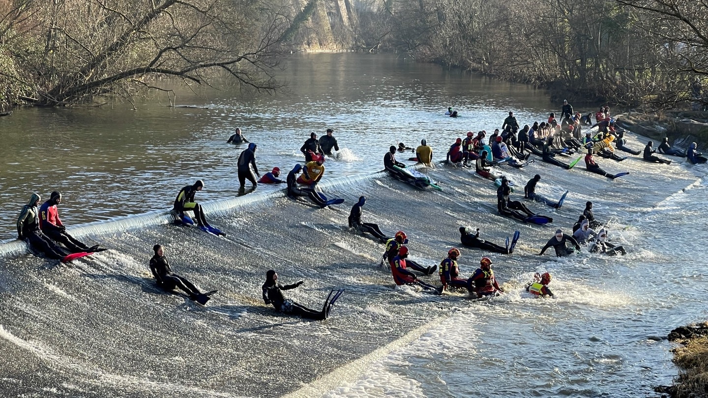 Kocherabschwimmen in Schwäbisch Hall an Silvester ist Tradition. Die Schwimmer rutschen eine Rampe im Fluss herunter.